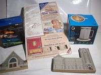 Group shot of all items: mug warmer box, Blu-ray set, wall stencil kit, two Cat’s Meow buildings