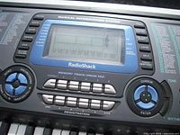 Close-up of LCD control panel, memory track/drum pad buttons, brand label