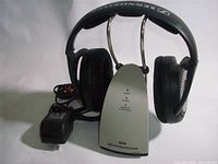 Headphones on transmitter base with adapter visible