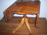 Table with one leaf down on wooden surface