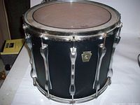 Front view of black Ludwig marching snare drum showing deep shell and chrome lugs