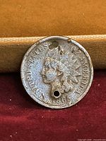 obverse of coin showing portrait, two holes, heavy wear