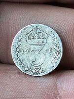 Reverse of 1918 British threepence coin showing crowned 3 and date
