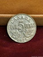 Reverse of 1926 Canada 5 cents coin showing denomination, maple leaves and date
