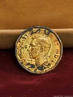 Obverse showing King George VI portrait with dark spotting on toned brass surface