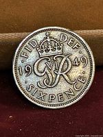Reverse side showing crowned royal monogram, date 1949, legend FID DEF SIXPENCE