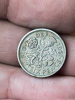 Reverse side showing date 1961 and denomination SIX PENCE with floral emblems
