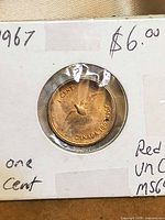 Reverse view of coin in flip showing rock dove design and handwritten holder notes