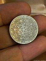 Obverse showing star design and Empire Cherifien text