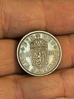 Reverse side of 1962 one shilling coin showing crowned Scottish shield and denomination