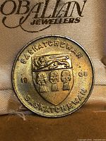 Obverse side showing Saskatchewan coat of arms with wheat sheaves, lion, date 1905, and wording 'SASKATCHEWAN'