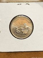 Reverse of Canadian 25-cent Wisdom coin showing elder, child, dog, sun, and legends