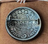 Reverse of coin showing coat of arms, date 1929, and pinned hardware