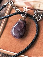 Necklace with amethyst pendant and chain extender on case