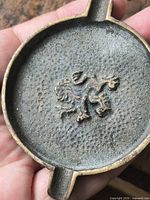 Front view showing lion relief and cigarette rests