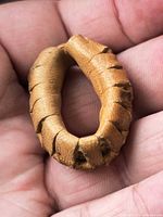 close-up of tan leather ring in hand showing laced edge construction