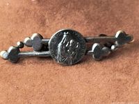 Front view showing devotional medallion and trefoil bar design