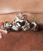 Front view of sterling silver Claddagh ring showing heart, hands and crown with gemstone