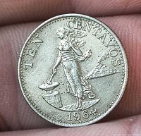 Obverse showing standing female, hammer and anvil, volcano, legend TEN CENTAVOS, date 1964