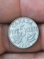 Reverse of 1928 Canada 5-cent coin showing denomination and maple leaves