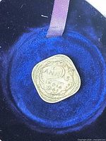 Reverse of 1941 2 Annas coin in blue case