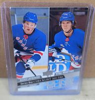 Front of Upper Deck 2020-21 Young Guns Checklist card #250 showing Alexis Lafreniere and Vitali Kravtsov in protective holder
