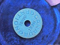 Front view of blue token showing full text and central hole