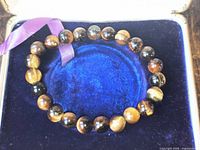 Bracelet in display box showing full circle of tiger's-eye beads