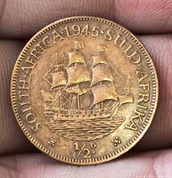 Reverse of 1945 South Africa coin with ship design and bilingual legend