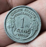 Reverse of 1959 French 1 Franc coin showing denomination, date, motto