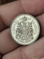 Reverse of 1969 Canada 50 cent coin showing Canadian Coat of Arms and denomination