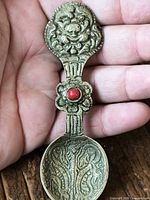 front view showing ornate relief and red stone