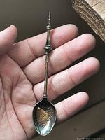 Front view of silver-plated CN Tower souvenir spoon in hand