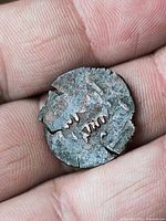 Obverse side showing worn motif and cracks