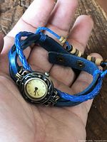 Watch face and strap cradled in hand showing scale and design details