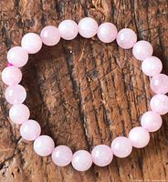 Top view of rose quartz bracelet laid flat showing full strand and bead uniformity