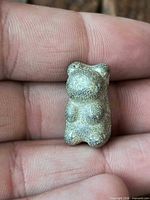 front view of solid pewter gummy bear sculpture on fingertips