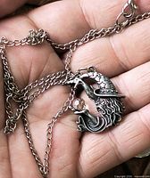 Necklace chain and wizard pendant in hand showing scale and detail