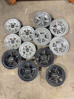 All 12 hubcaps arranged on floor showing quantity, colors and styles