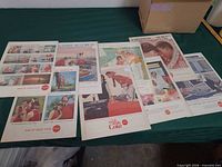 Group shot of all seven vintage Coca-Cola ads laid out on a table