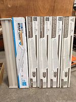 Five boxed GreenChoice fixtures and one loose 48-in wrap fixture