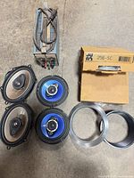 Group shot: power supply, four speakers, three mounting rings, cardboard box