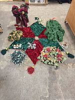 Entire lot laid out: tree skirt, garland, floral bouquets, picks, lights, ornaments visible