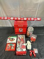 All items grouped: doll, snow globe, bank, ornaments, plush, wrap, ribbon