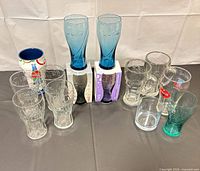 Assorted Coca-Cola glasses arranged together showing colours, shapes and boxed items