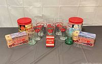 Full lot showing glasses, tins, green glass, playing cards