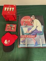 Group shot showing sign, boxed glasses, hat and playing card tin