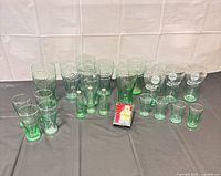 Group shot of all green Coca-Cola glasses, three bottle shakers and deck of cards