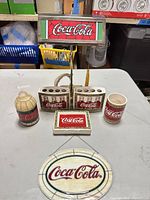 Front view of all seven Coca-Cola items displayed together on table
