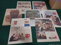 Seven ad pages laid out on table